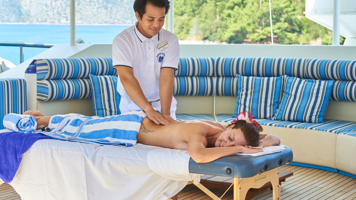 guest having massage on the table on ship deck