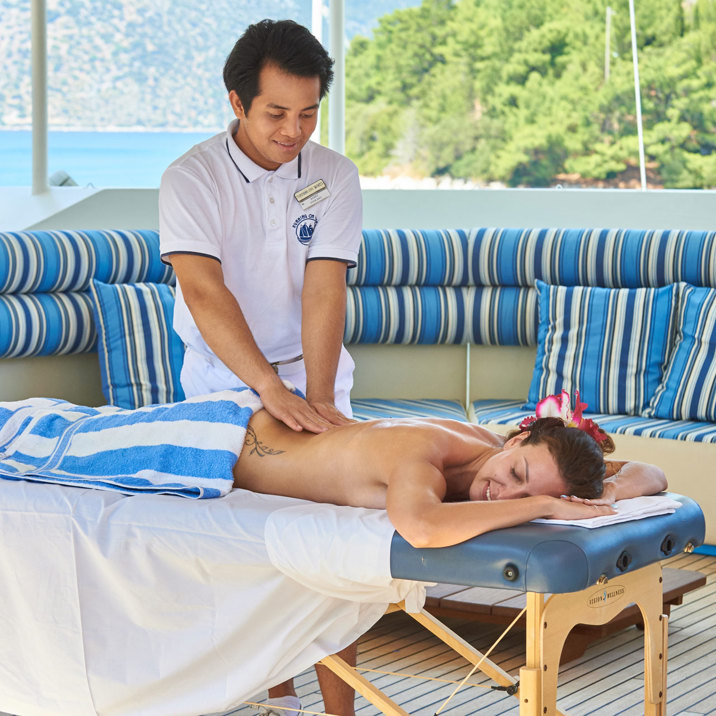 guest having massage on the table on ship deck