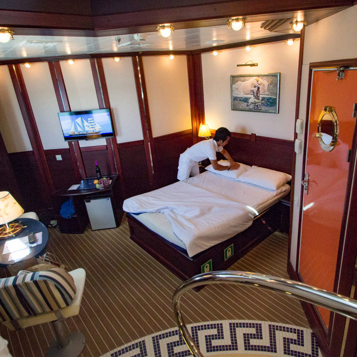 crew cabin service making the beds in a large cabin