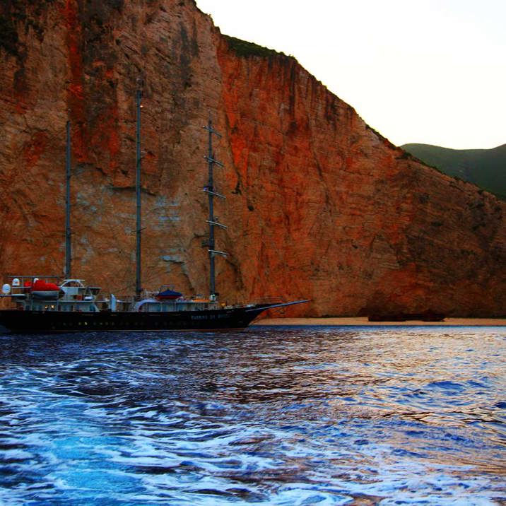 ship at the coast next to red rocks