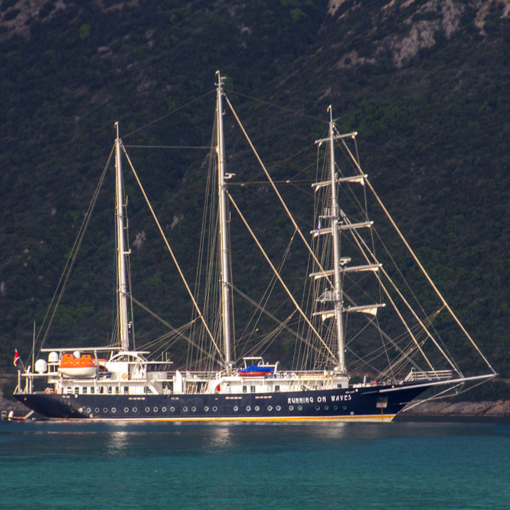 ship close up next to green island hill slopes