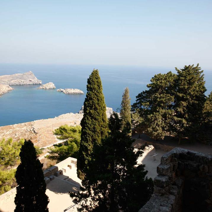 island rocky pine tree hilltop view with temple ruins