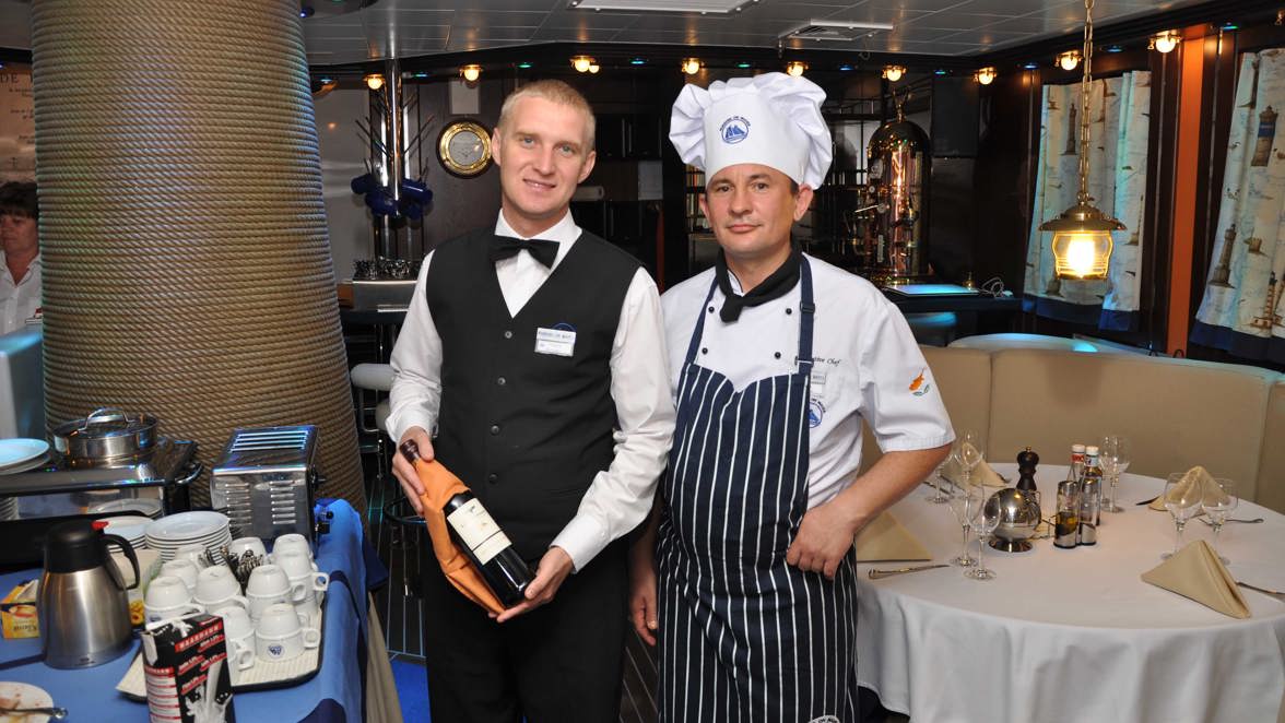chef and waiter in the restaurant with wine bottle