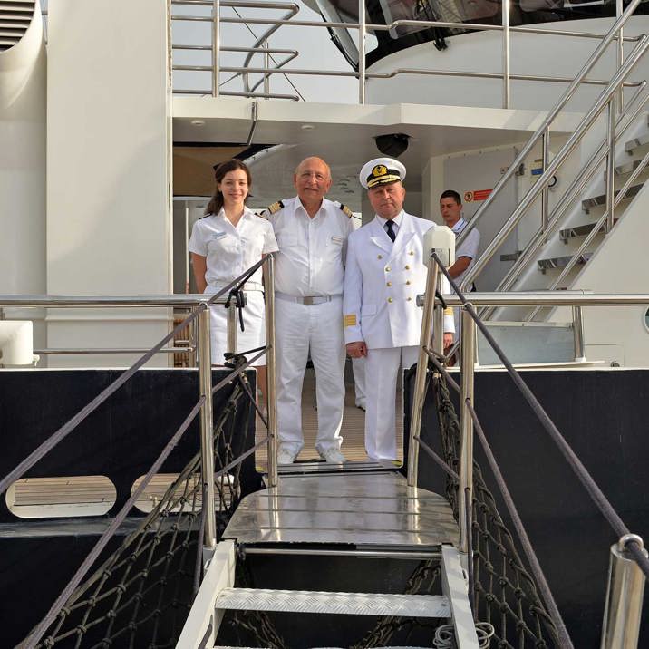 captain and assistants on deck in front of the hardor bridge