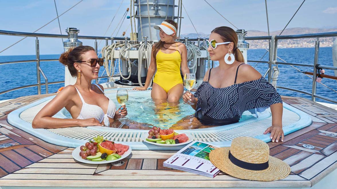guests in jacuzzi with wine and fruits