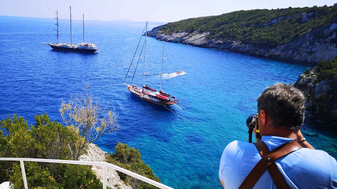 guest photographer taking photo of ship and boat next to island