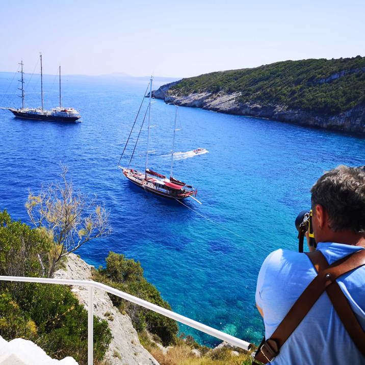 guest photographer taking photo of ship and boat next to island