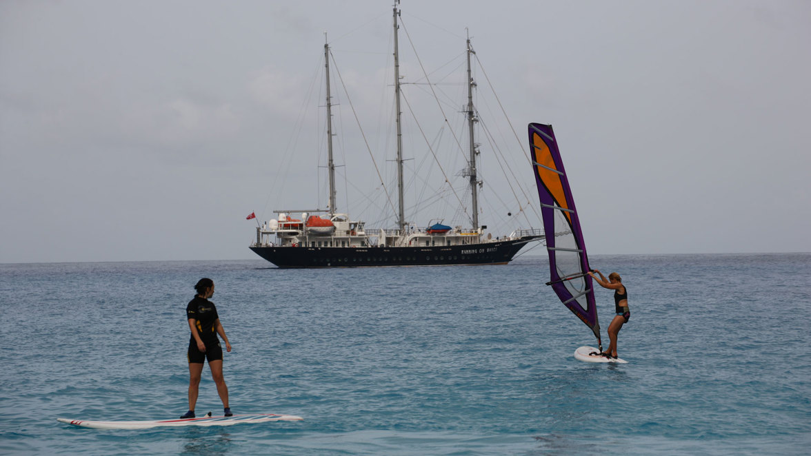 guests windsurfing near ship