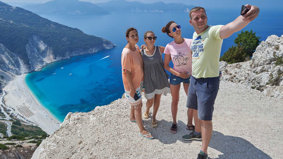 guest taking photo on hilltop near beach