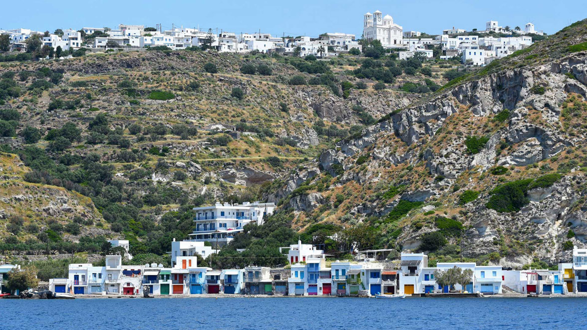 coastal island town with white houses and rocky hills