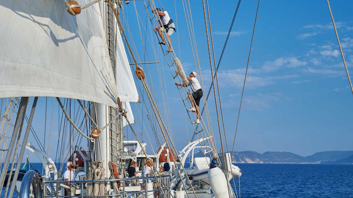 guest climbing mast above crew member