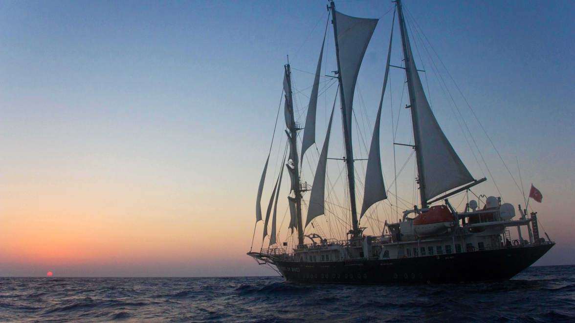 ship on waves at sea at sunset